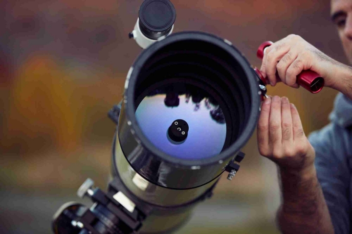 Astrónomo manipulando telescopio.