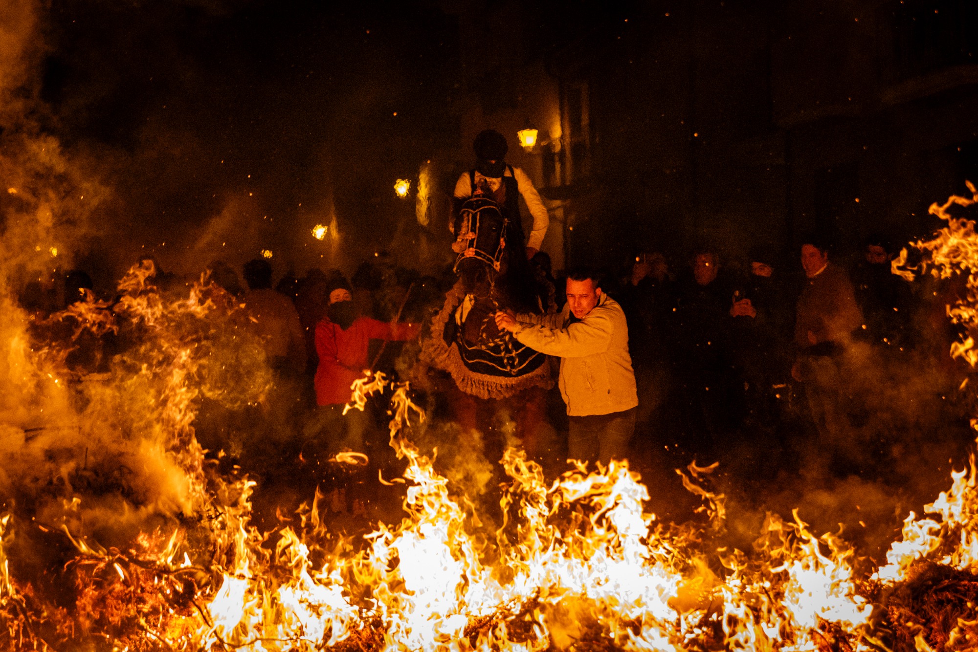 Más de 2000 personas se congregan para correr y saltar el fuego junto a caballos y jinetes.