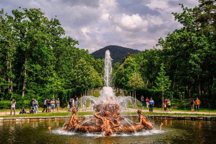 La fuente de Canastillo, en calma, rodeada de árboles con las montañas al fondo, esencia de los jardines.