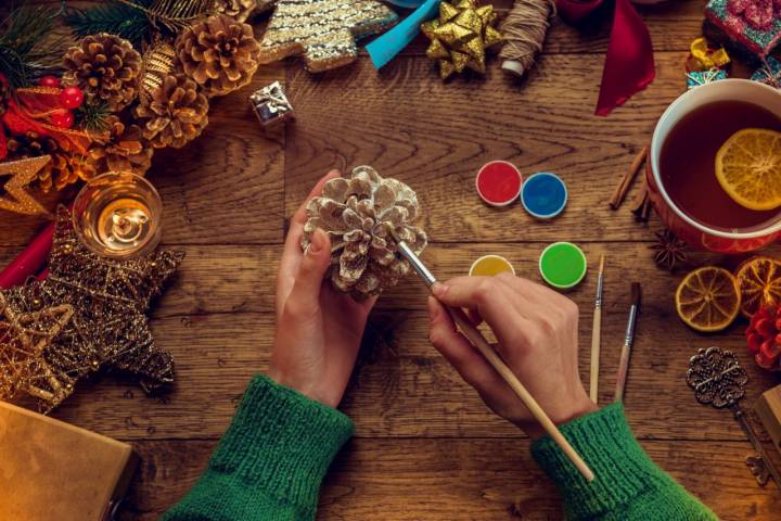 Pintando de colores piñas para la decoración de Navidad.