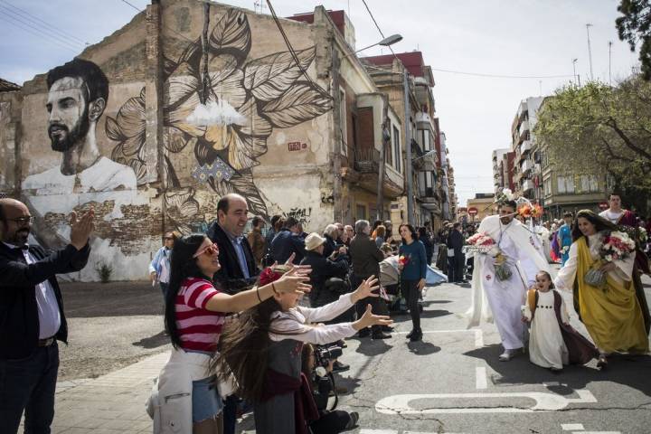 Los asistentes extienden las manos para recoger las flores que se lanzan el Domingo de Resurreción.