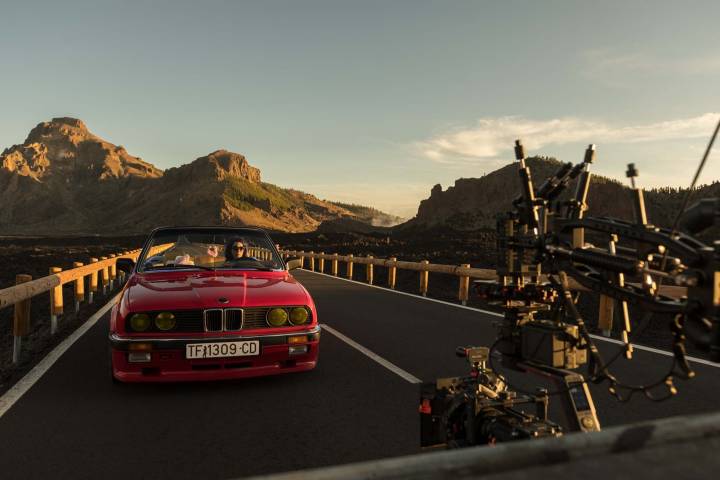 Un coche rojo circula por la carretera