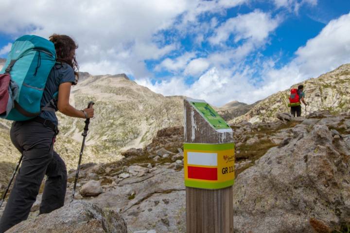 Montañistas ascendiendo hacia el Collado de La Plana en el Parque Natural Posets-Maladeta (Huesca).