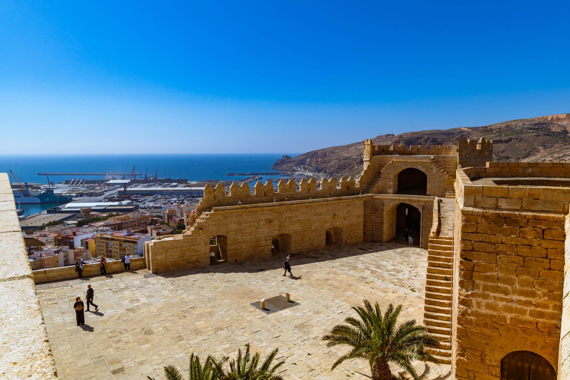 Patio de armas desde la torre del homenaje, con el paseo de ronda con el puerto al fondo. 