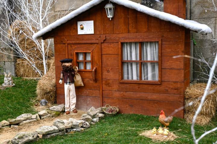 Muñeco y cabaña de madera.