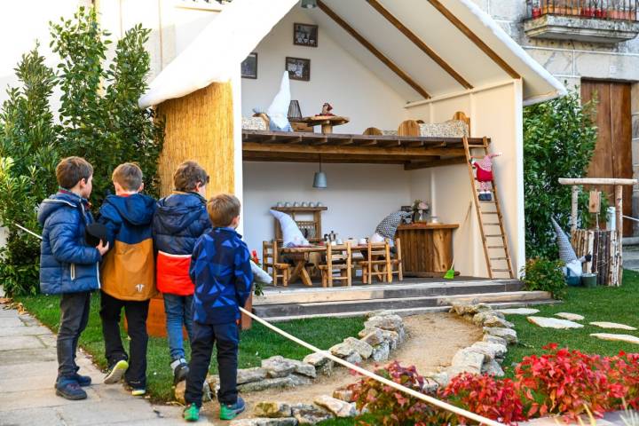 Niños mirando una casita de duendes.