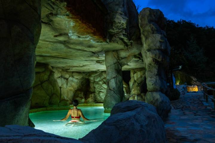 Chica bañándose en una piscina de balneario en plena noche.