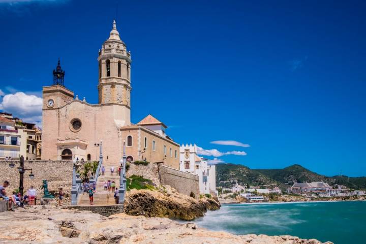 Una pareja descansa a la sombra, junto a la estatua de la mujer mediterránea, en Sitges.