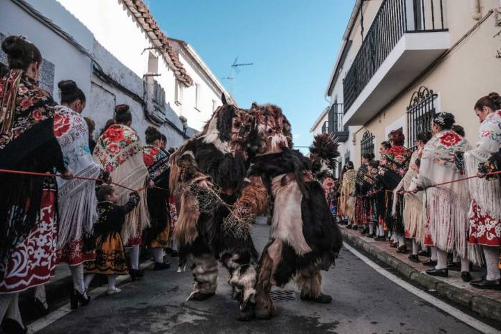 Dos carantoñas esperan a San Sebastián rodeadas de 'regaoras'.