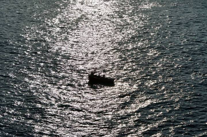 Vistas de un barco en el mar durante la puesta de sol, en Luarca, Asturias.