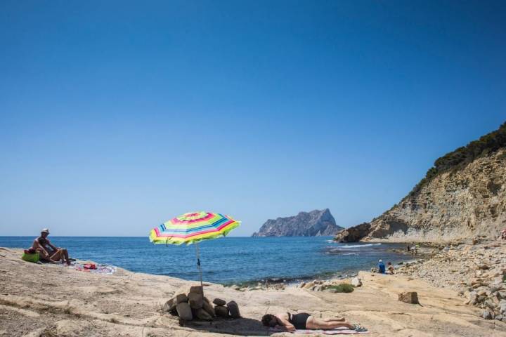 Un pareja toma el sol en la cala del Mallorquín, Calpe, Alicante.