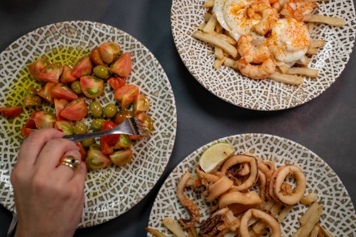 Restaurante La Ola. Calamares fritos, ensalada de tomate Raff y huevos rotos con gambas.