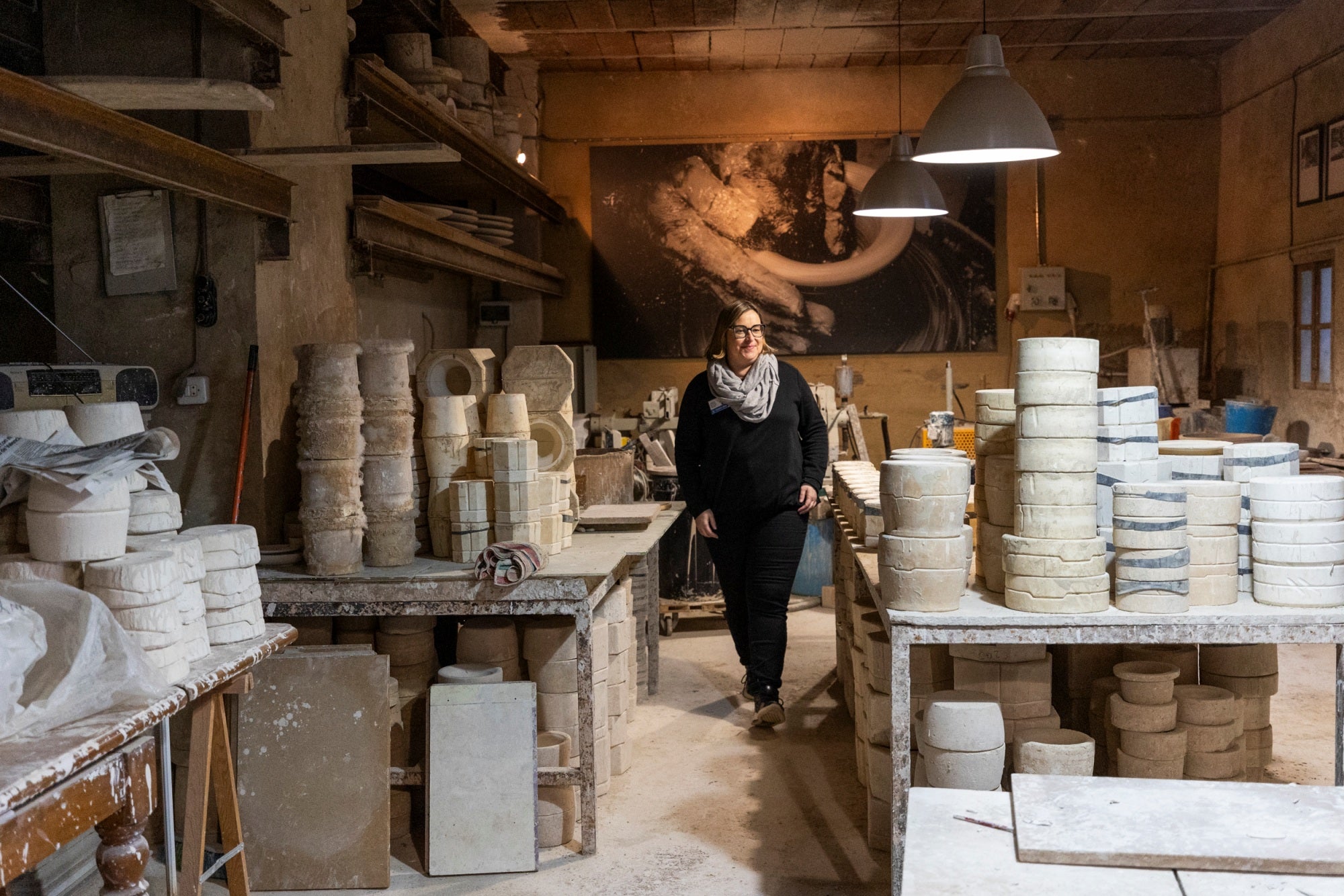 Mujer paseando por un taller de cerámica.