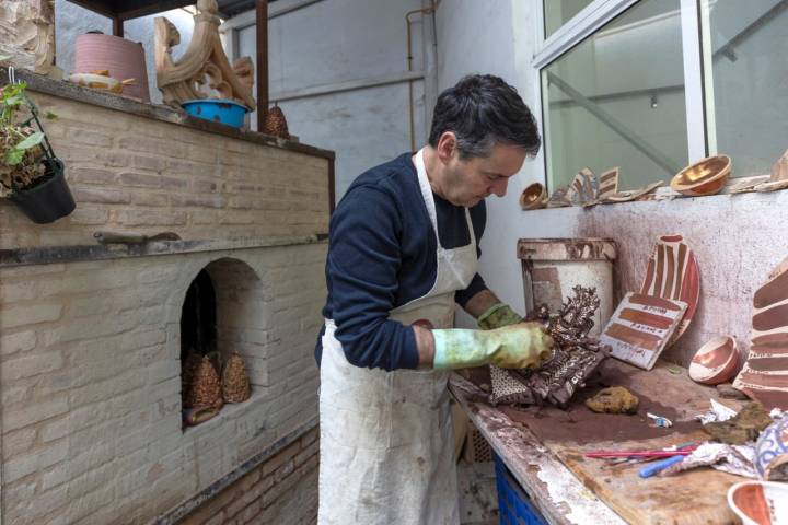 Arturo limpiando una pieza con un cepillo.