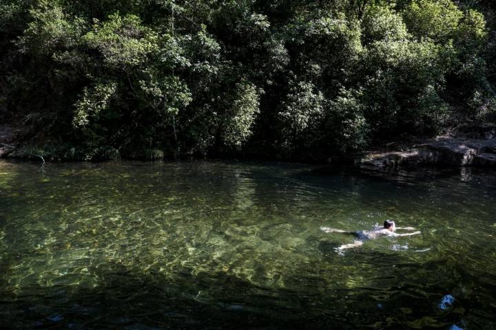 Un hombre nada en la piscina natural de Pelayo.