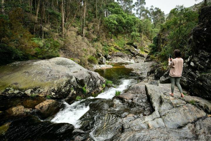 Una mujer toma una foto en las pozas del río Barbanza