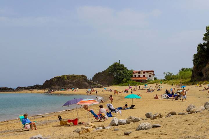 Una playa dorada que descansa bajo el monte verde.