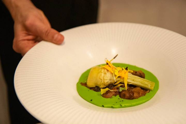 Alcachofa confitada sobre una crema de vegetales y un salteado de langostinos y shiietake.