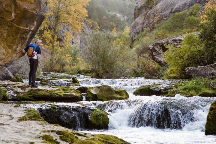 Un hombre observa el nacimiento del río Pitarque