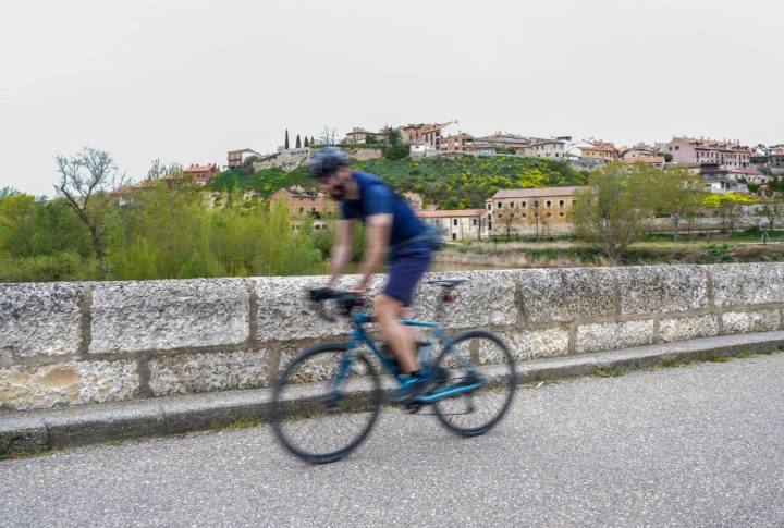 Un ciclista cruza un puente de Simancas (Valladolid)