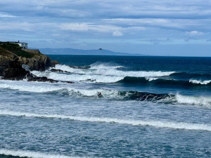 Surfista cogiendo olas en la playa de Tapia de Casariego