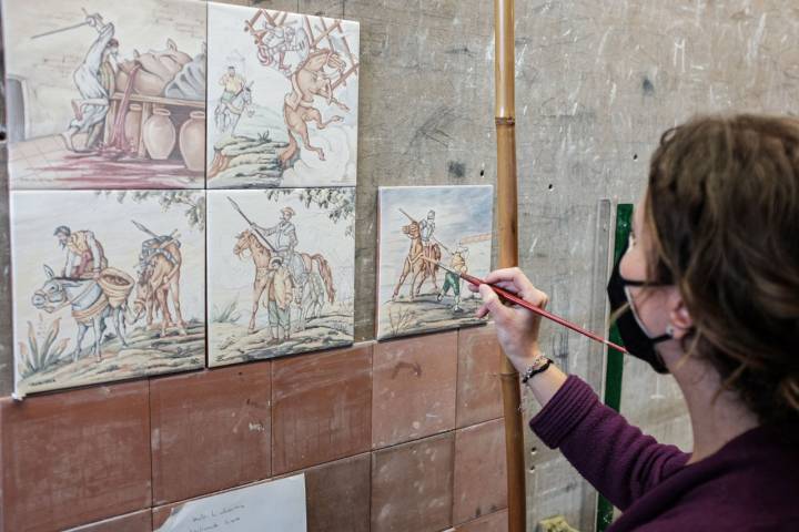 Una ceramista pinta a mano uno azulejo en el centro Artesanía Talaverana.