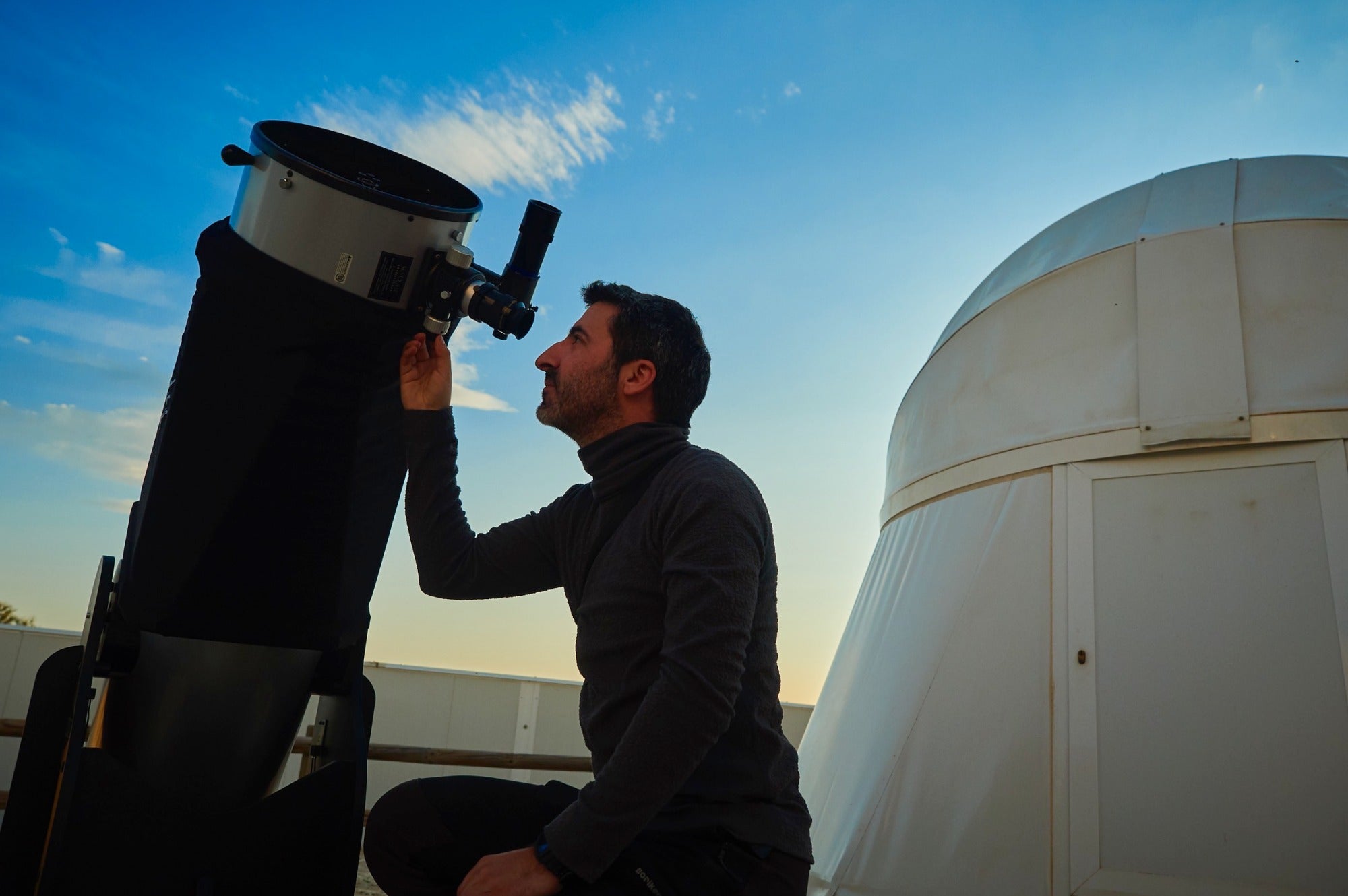 Una persona coloca un telescopio en Astrocamp en Nerpio